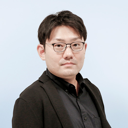 加藤宗佑の顔写真です。黒いスーツとシャツを着ており、黒淵の眼鏡をかけています。